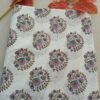 White fabric with blue and beige floral vine designs