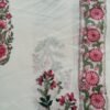 White fabric with pink rose motifs and green leaves